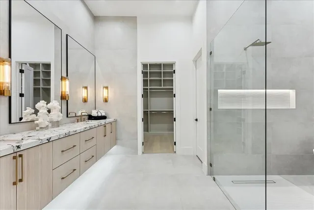 a bathroom with a sink and mirror with shower