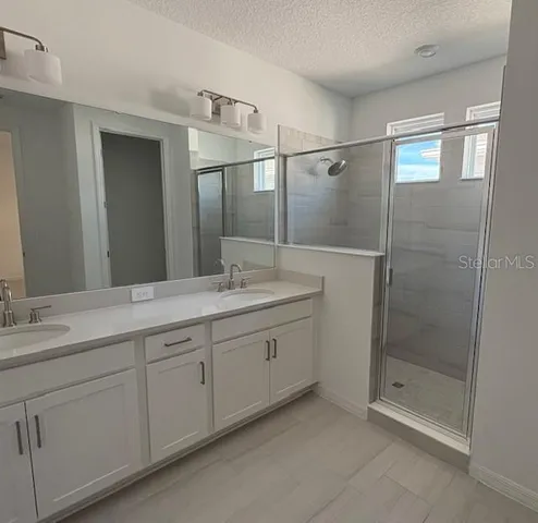 a large kitchen with stainless steel appliances kitchen island a large counter top and wooden floors