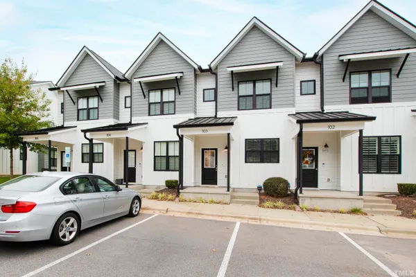 a car parked in front of a white house