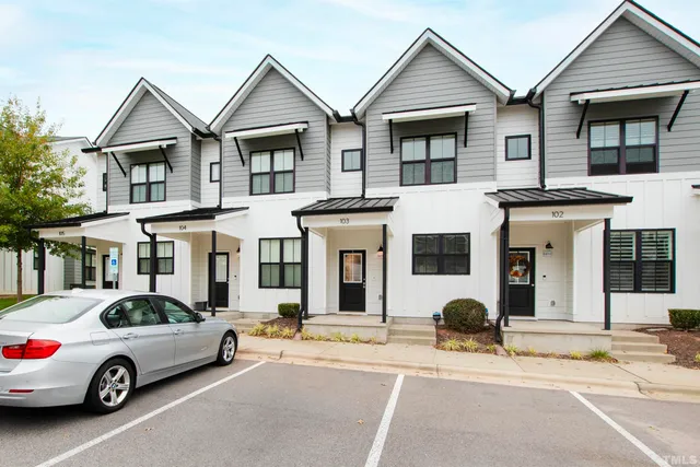 a car parked in front of a white house