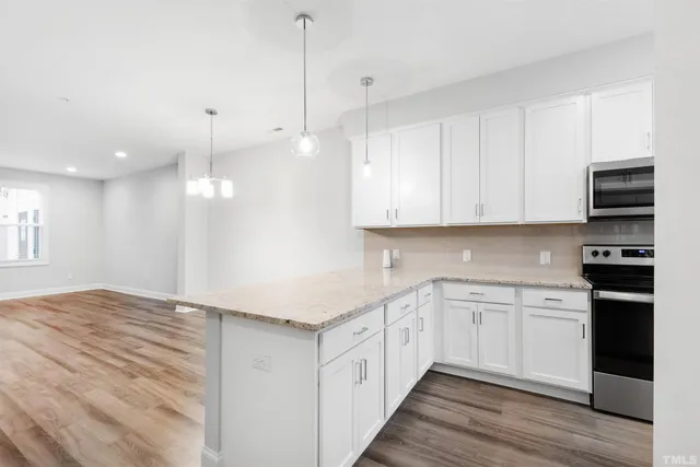 a kitchen with stainless steel appliances granite countertop a sink and white cabinets