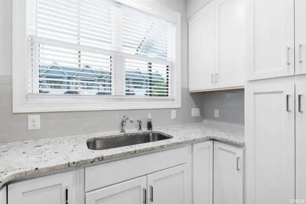 a kitchen with granite countertop white cabinets and a sink