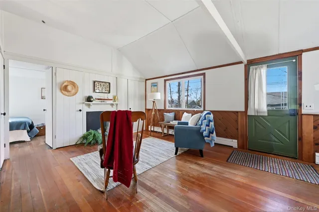 a living room with furniture a wooden floor and a potted plant
