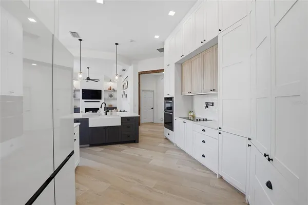 a large white kitchen with stainless steel appliances