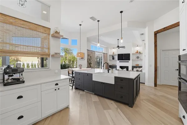 a view of kitchen with stainless steel appliances kitchen island granite countertop a sink a stove and a wooden floors