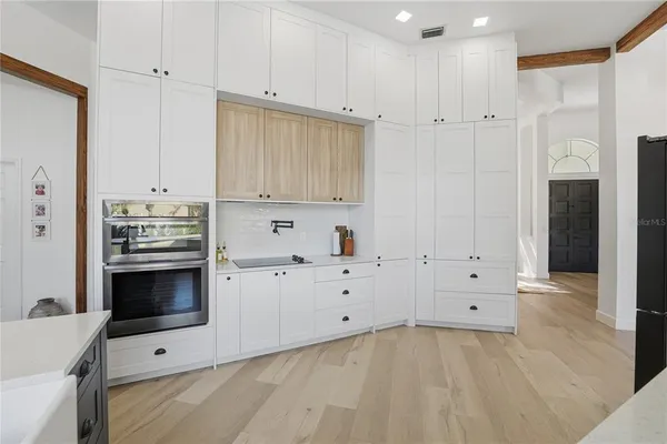 a kitchen with granite countertop white cabinets and stainless steel appliances