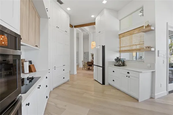 a large white bedroom with bed and a large mirror