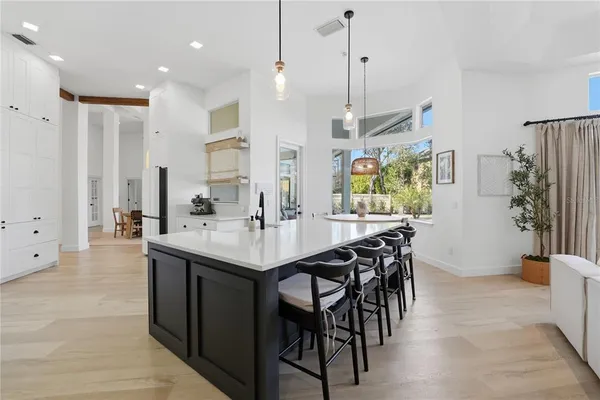 a kitchen with stainless steel appliances kitchen island granite countertop a table chairs and a refrigerator