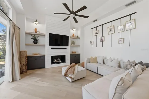 a living room with furniture a fireplace and a flat screen tv