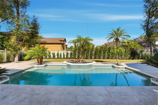 a view of swimming pool with outdoor seating and a garden