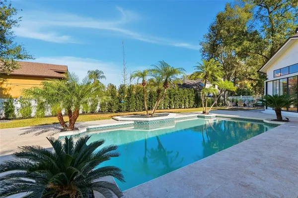 a view of a patio with table and chairs potted plants and a large tree