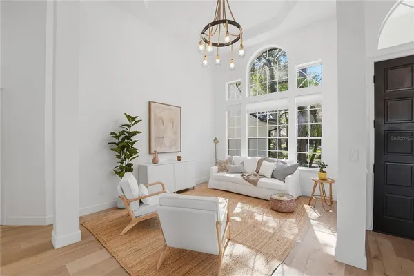 a living room with furniture chandelier and a table