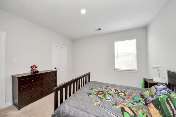 a kids bedroom with a bed and a window