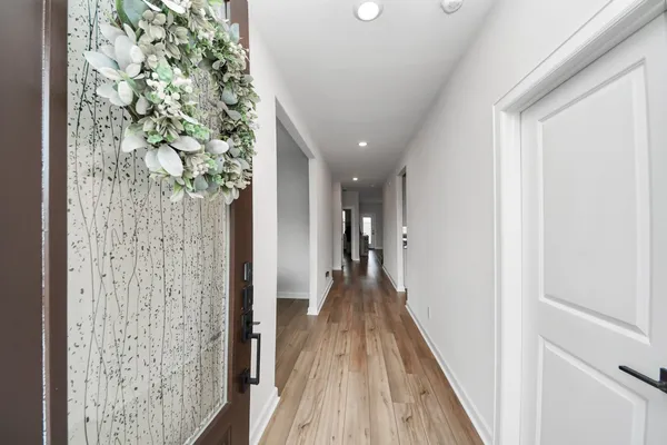 a view of a hallway with wooden floor and stairs