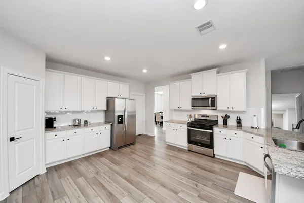 a kitchen with white cabinets and stainless steel appliances