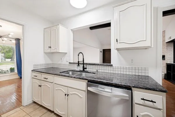 a kitchen with granite countertop white cabinets and white appliances