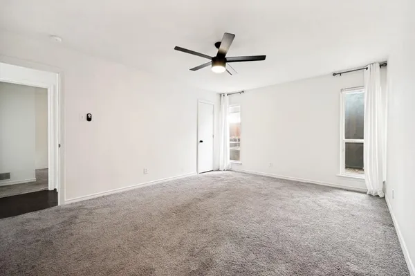 an empty room with closet and windows
