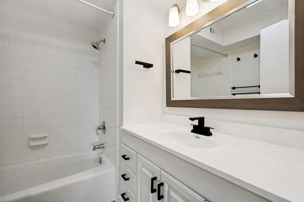 a bathroom with a sink a mirror and a bathtub