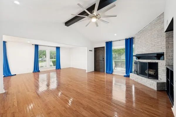 a view of an empty room with window and fire place