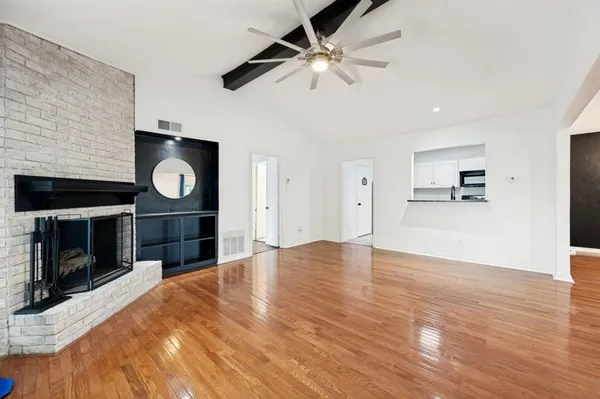 a view of empty room with wooden floor and fireplace