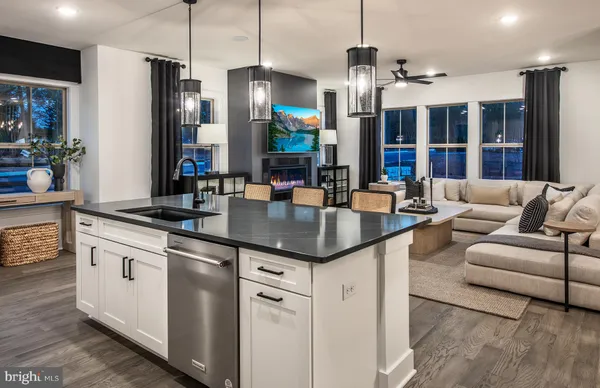 a kitchen with granite countertop a sink a counter top space cabinets and stainless steel appliances
