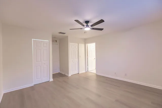 an empty room with a window and a fan
