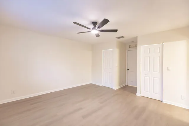 an empty room with a window and a fan
