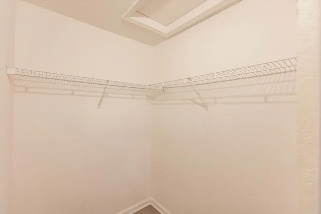 an empty room with a window and a ceiling fan