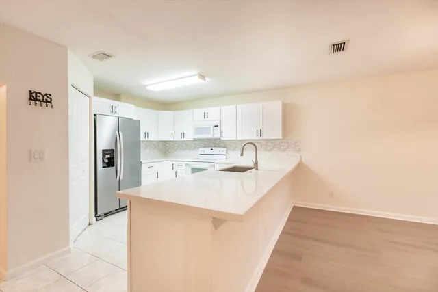 a kitchen with white cabinets and white appliances
