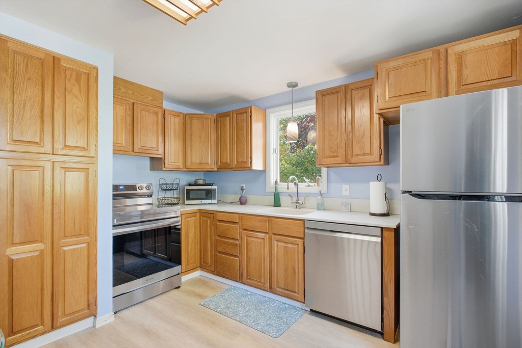 28 Collingwood Road Springfield, MA 01119 - Photo 9 of 32 a kitchen with a sink a refrigerator and cabinets