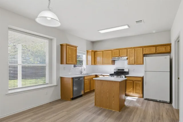a kitchen with stainless steel appliances granite countertop a stove a sink dishwasher and a refrigerator
