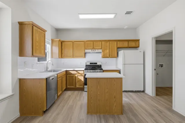 a kitchen with a stove a refrigerator and a sink