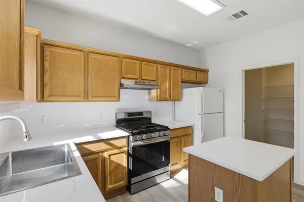 a kitchen with stainless steel appliances a stove a sink and a refrigerator