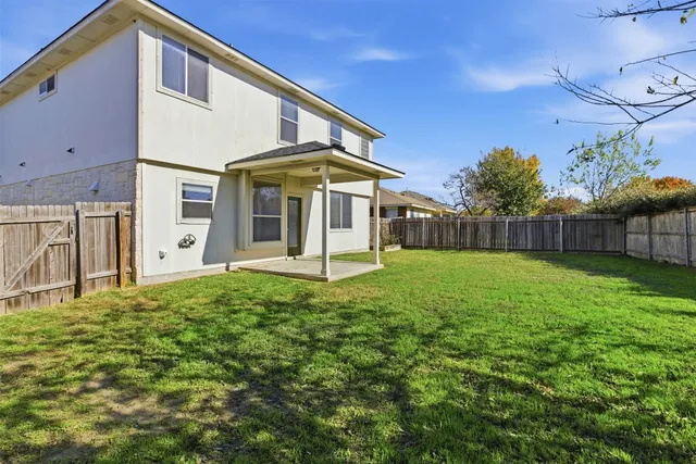 a view of a house with backyard and porch