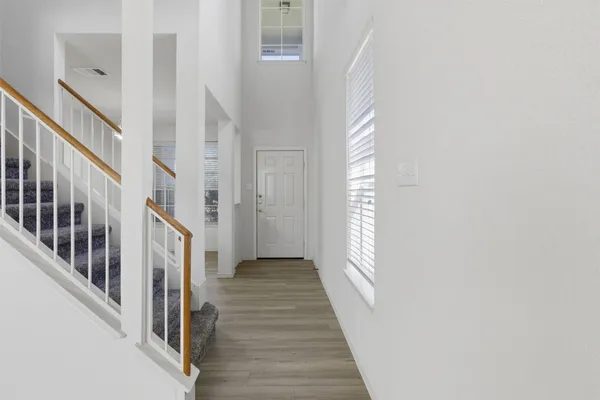 a view of a hallway with wooden floor and entryway