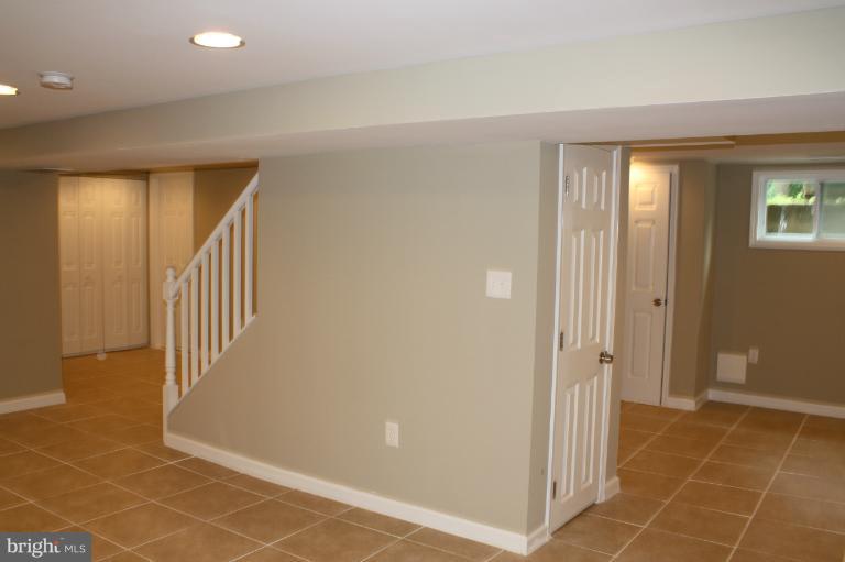9314 Sudbury Road Silver Spring, MD 20901 - Photo 16 of 30 a view of a hallway with wooden floor and a bathroom