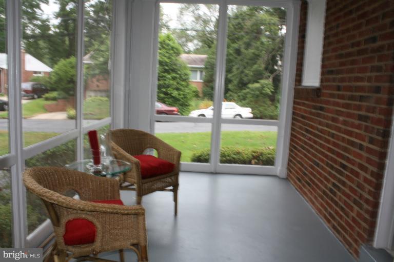 9314 Sudbury Road Silver Spring, MD 20901 - Photo 17 of 30 a view of a porch with furniture and wooden floor