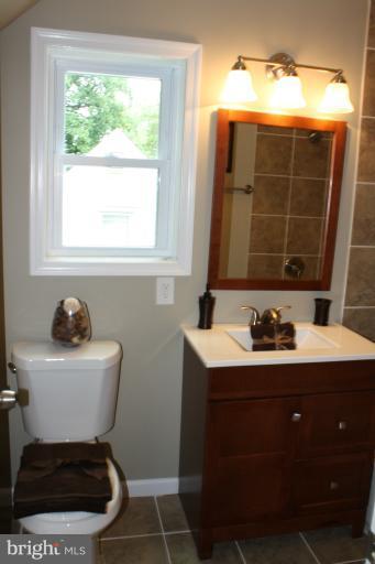9314 Sudbury Road Silver Spring, MD 20901 - Photo 9 of 30 a bathroom with a toilet sink and mirror
