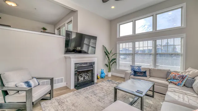 a living room with furniture a fireplace and a flat screen tv