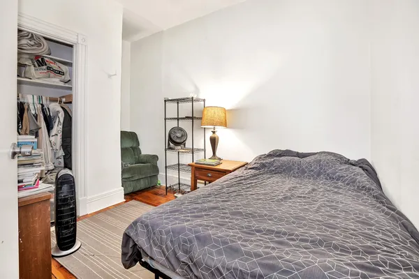 a bedroom with a bed and a flat tv screen on the dresser