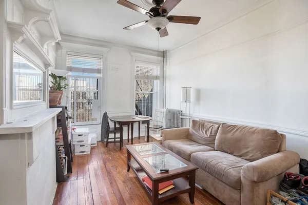 a living room with furniture a wooden floor and a chandelier