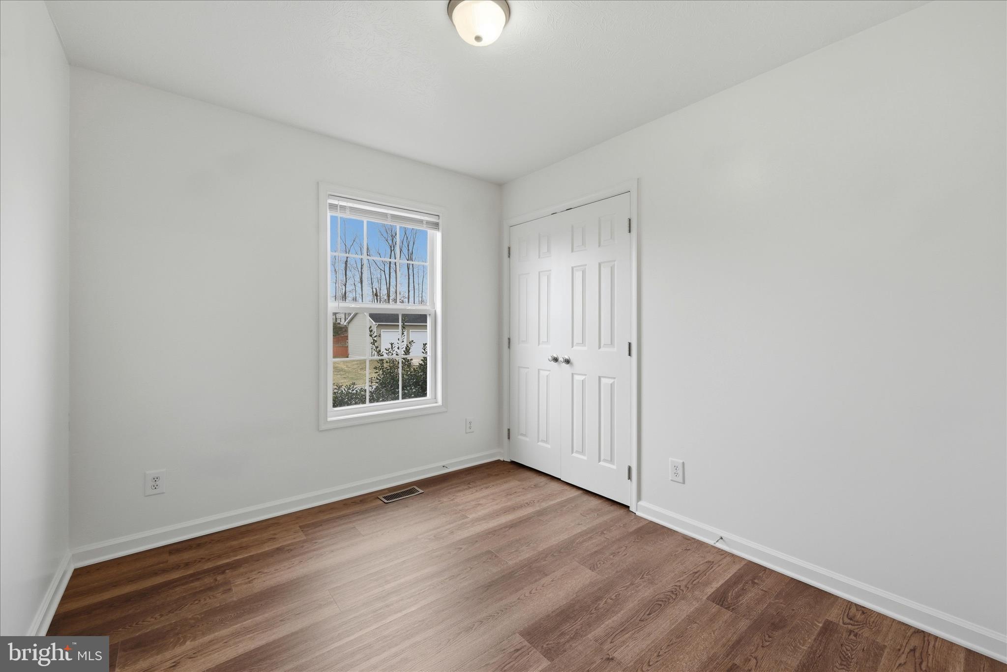 104 Basin Drive Inwood, WV 25428 - Photo 12 of 26 an empty room with wooden floor and windows