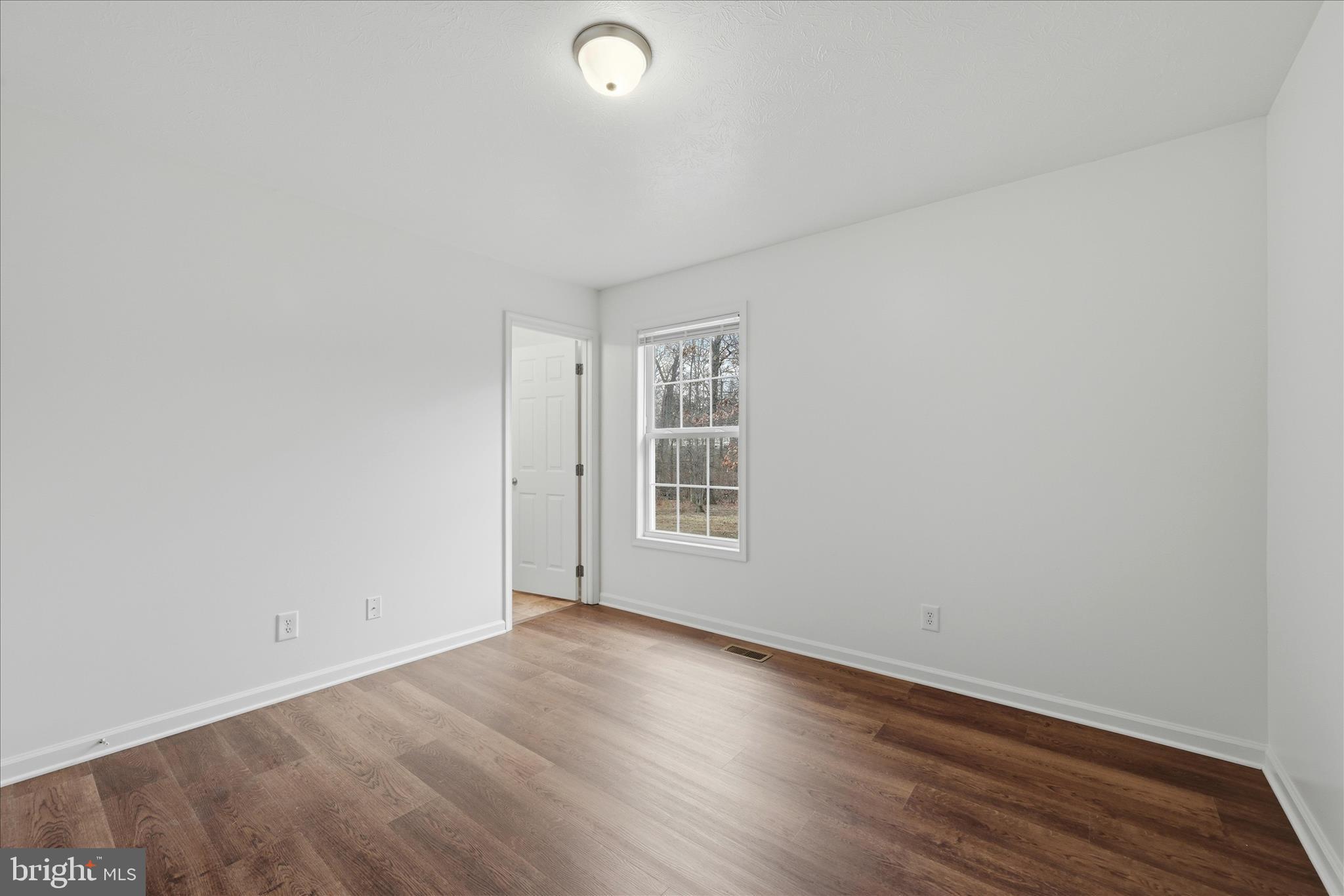 104 Basin Drive Inwood, WV 25428 - Photo 17 of 26 an empty room with wooden floor and windows