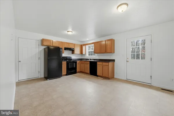 a kitchen with stainless steel appliances granite countertop a refrigerator and a stove