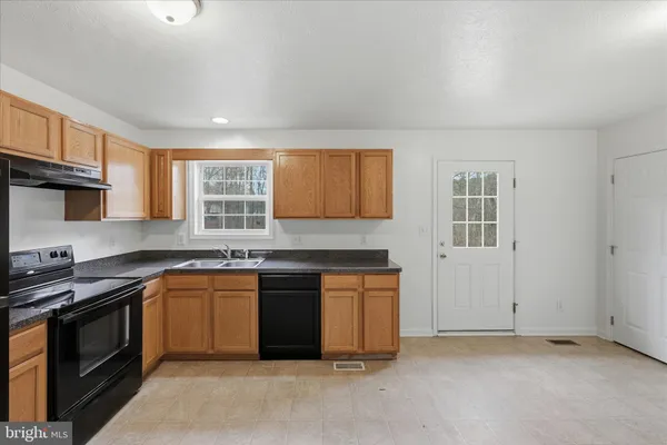 a kitchen with stainless steel appliances granite countertop a stove sink and cabinets