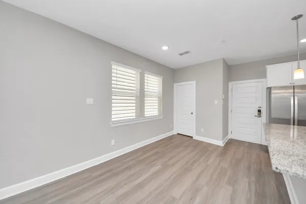 a large kitchen with stainless steel appliances granite countertop a lot of counter space and wooden floor