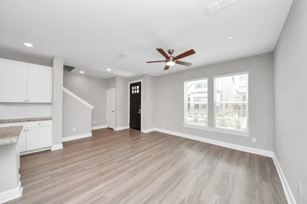 a view of an empty room with a window and wooden floor