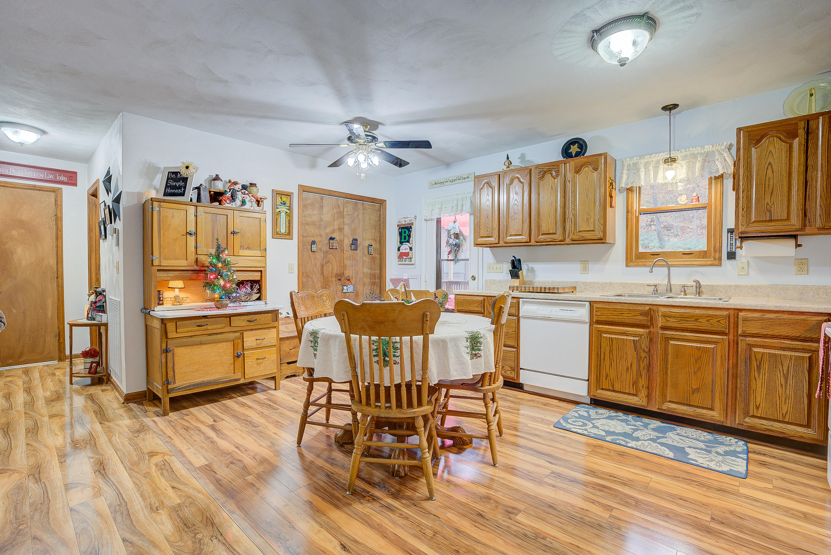 1037 Buck Mountain Road Goodview, VA 24095 - Photo 11 of 31 a kitchen with stainless steel appliances granite countertop a refrigerator a sink dishwasher a dining table and chairs with wooden floor