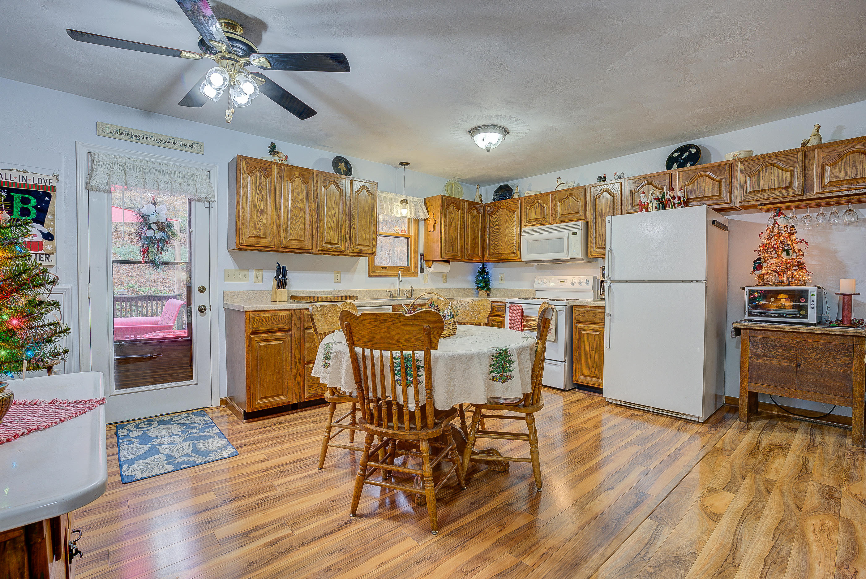 1037 Buck Mountain Road Goodview, VA 24095 - Photo 12 of 31 a kitchen with stainless steel appliances a refrigerator a stove a sink dishwasher and a dining table with wooden floor