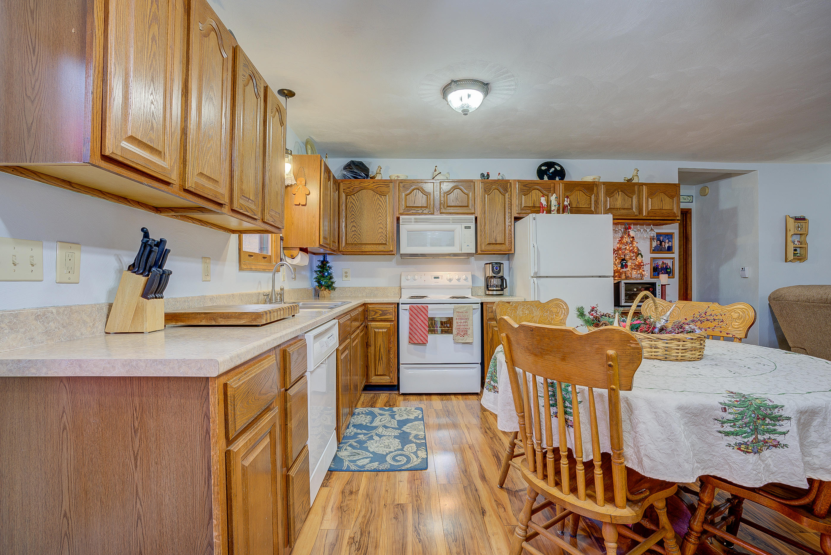 1037 Buck Mountain Road Goodview, VA 24095 - Photo 14 of 31 a kitchen with stainless steel appliances granite countertop a sink a stove a dining table and chairs with wooden floor